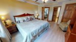Spacious master bedroom suite with a king bed, TV, and bathroom access